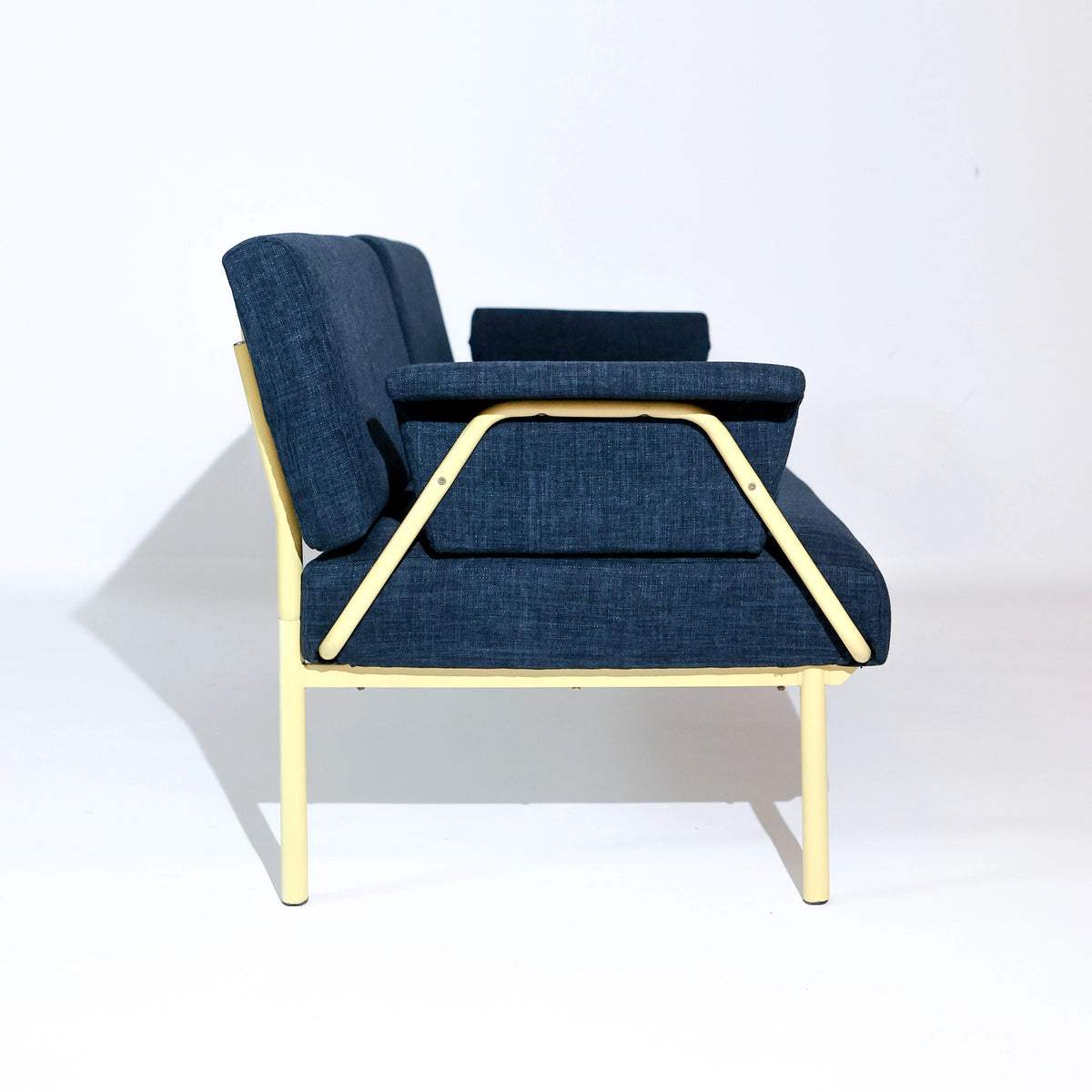 Sofá de inspiración Bauhaus vintage, tapicería azul oscuro y estructura tubular amarillo brillante